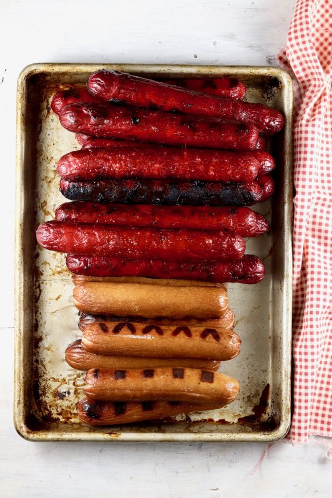 Grilled Hot Dogs, Smoked Sausage Links, and Hot links on a sheet pan, red napkin