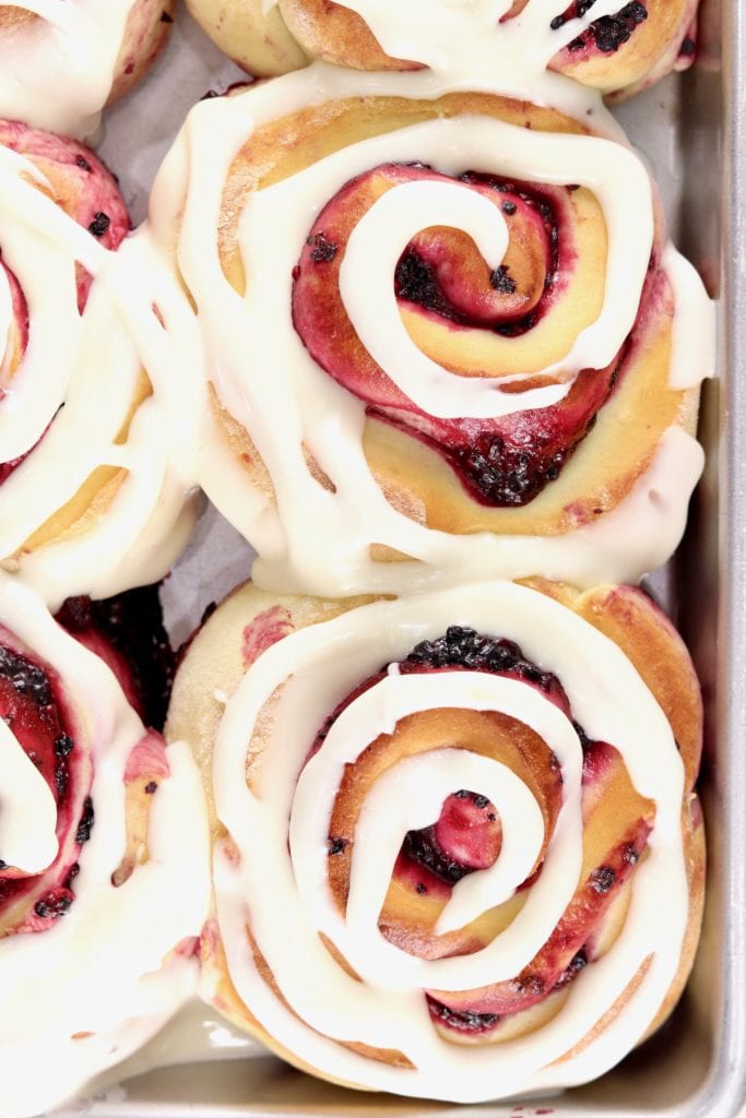 Close up of sweet rolls with swirled icing in a pan