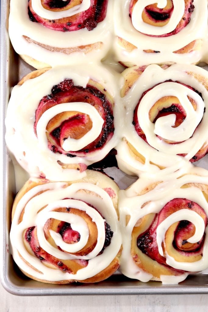 Pan of blackberry filled sweet rolls with cream cheese swirled icing
