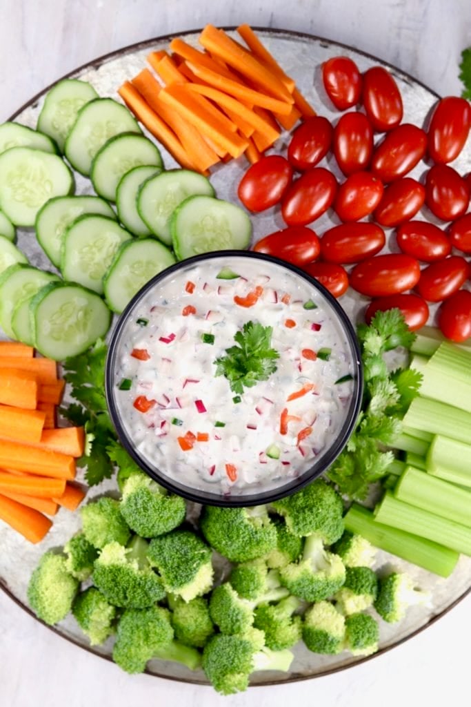 Creamy Dip with cut up carrots, cucumbers, broccoli, and grape tomatoes on a platter