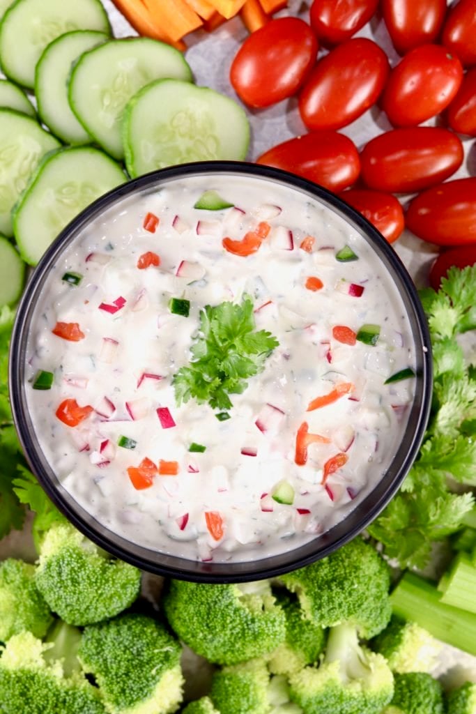 Bowl of vegetable dip surrounded by sliced vegetables for dipping