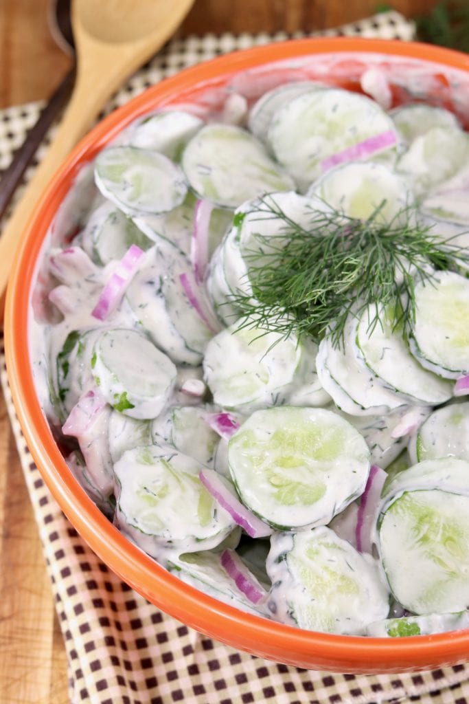 Bowl of sliced cucumbers in creamy dressing