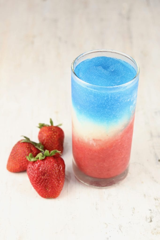 Firecracker - red, white and blue daiquiri frozen cocktail with fresh strawberries