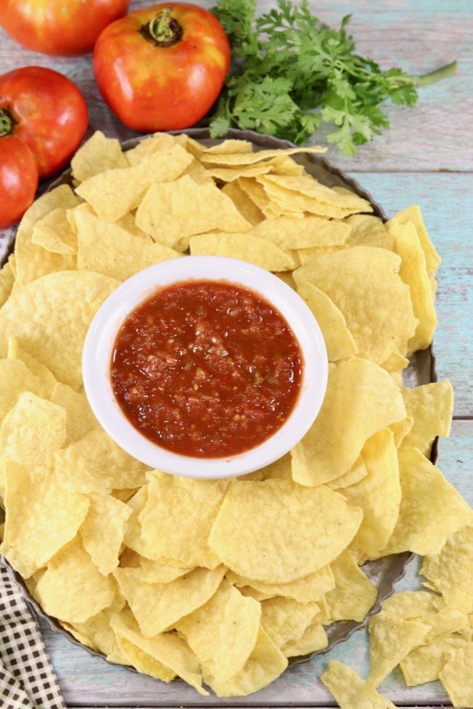Tomatoes and cilantro with platter of chips and salsa