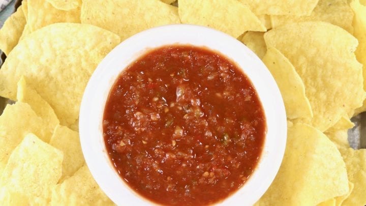 Platter of tortilla chips and white bowl of salsa