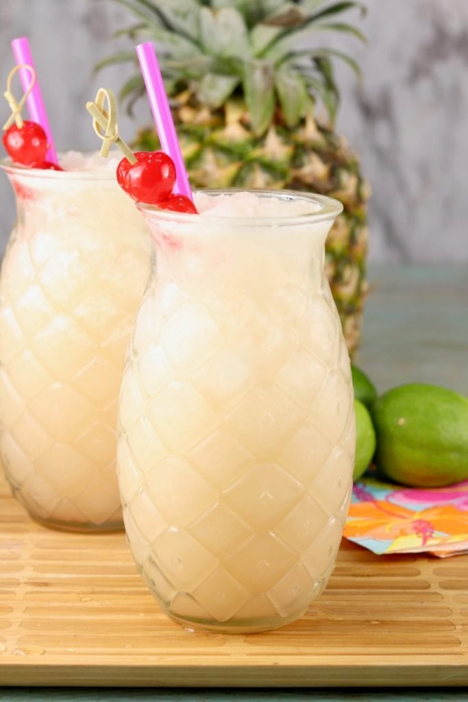 Pineapple shaped glasses with pineapple coconut wine party punch garnished with a cherry