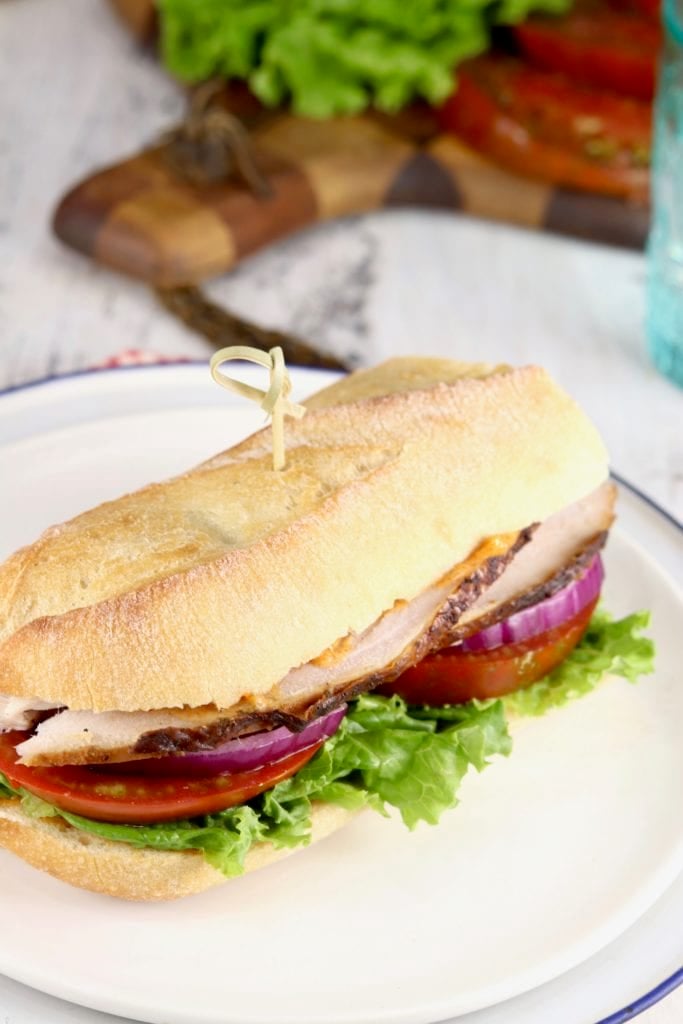 Baguette sandwich with smoked turkey, tomato, lettuce and red onion