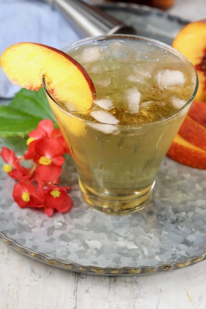 Peach Old Fashioned Cocktail garnished with a fresh peach slice