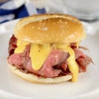 Roast Beef Sandwich with cheddar sauce on a white plate