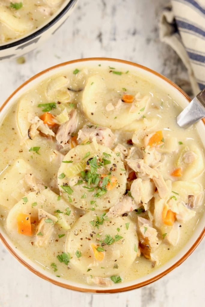 Bowl of creamy soup with turkey, carrots and dumplings