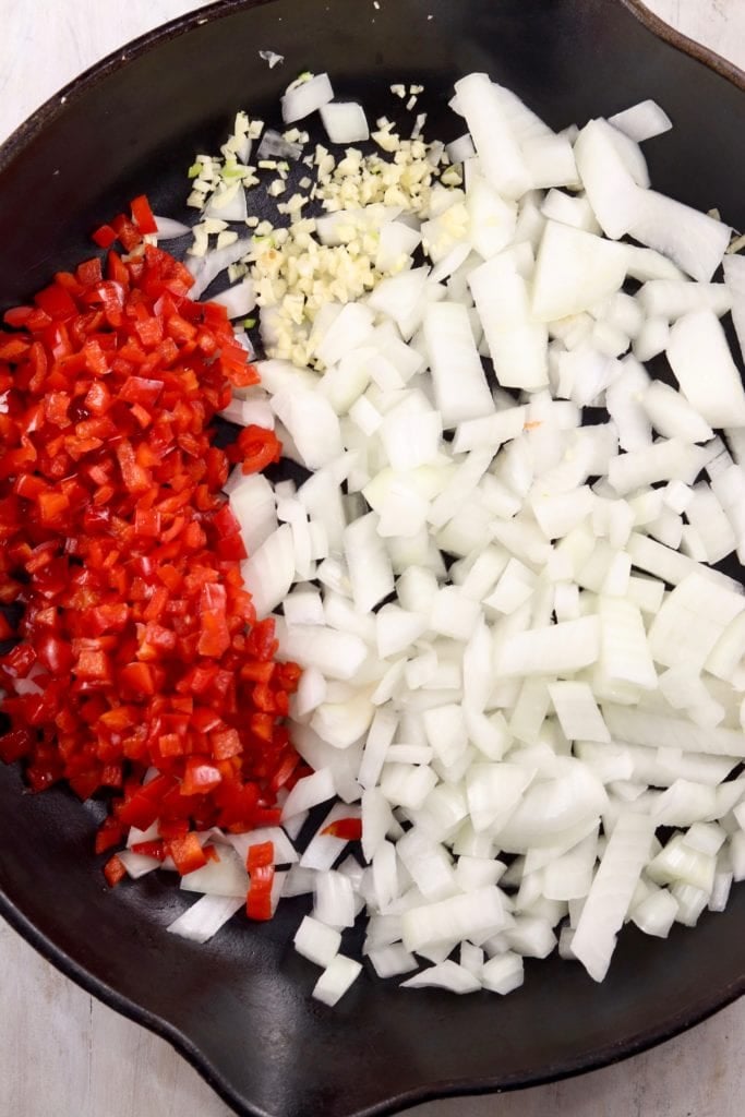 Skillet of chopped onions, red bell peppers and garlic