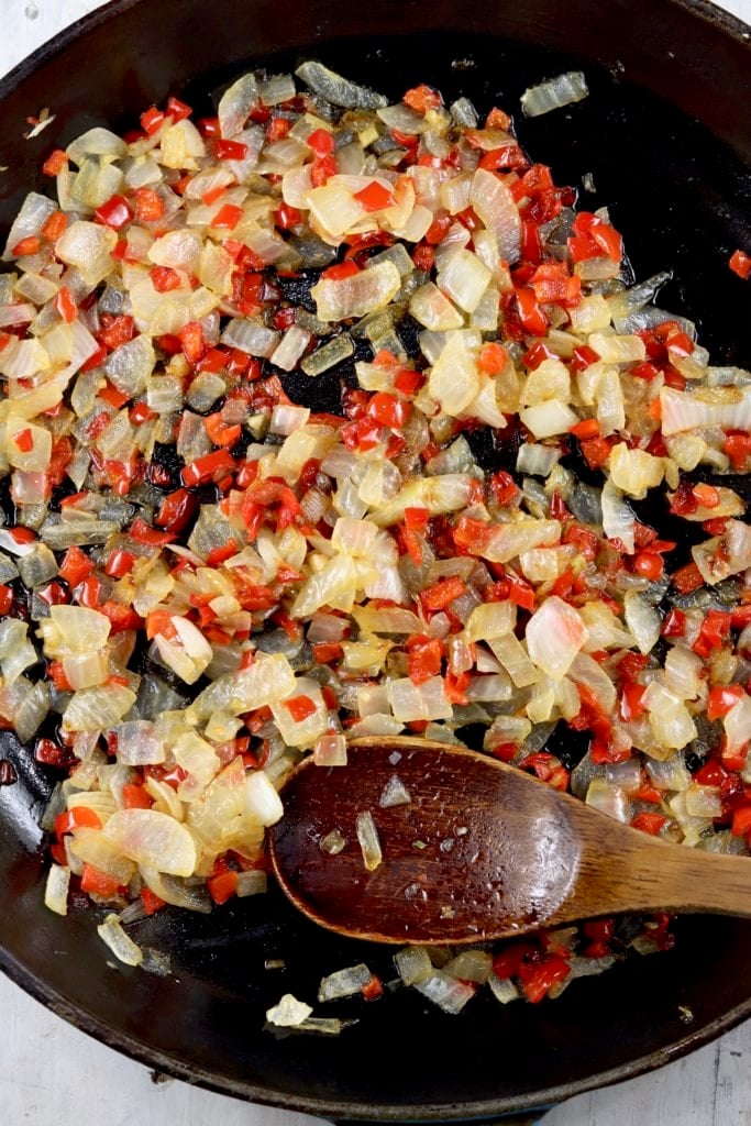 Cooked peppers and onions in a skillet