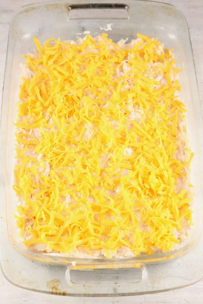 potato casserole topped with shredded cheese ready for the oven