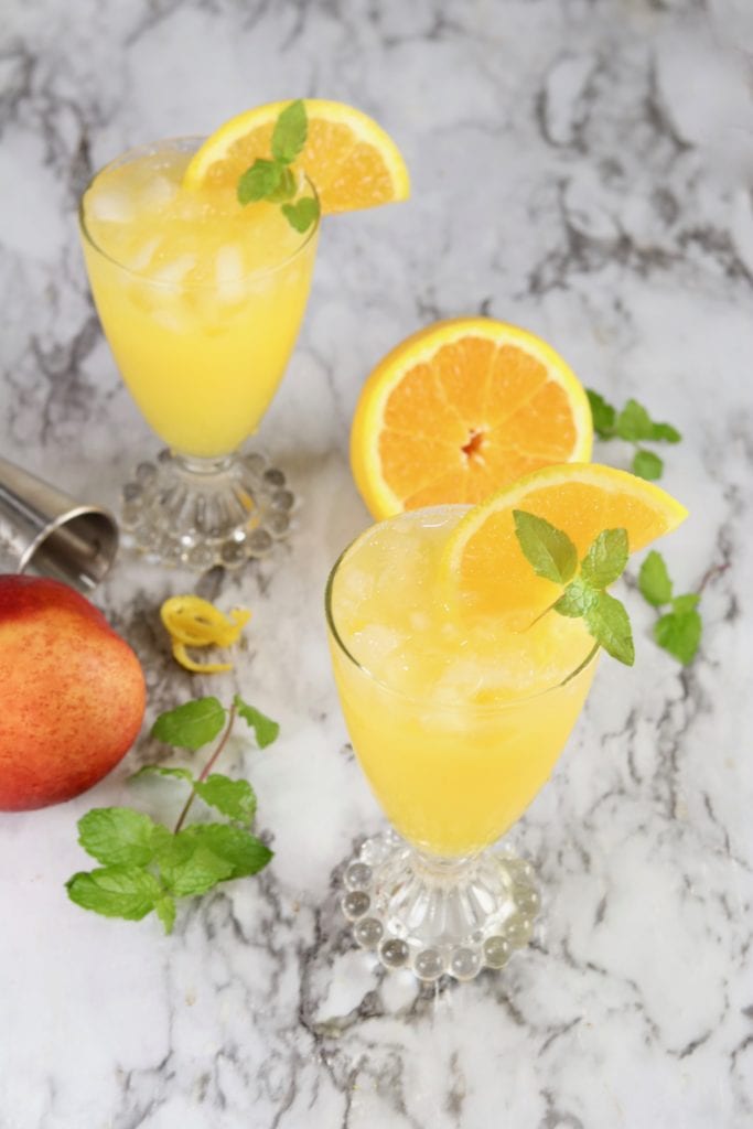 Orange juice cocktail with mint garnish