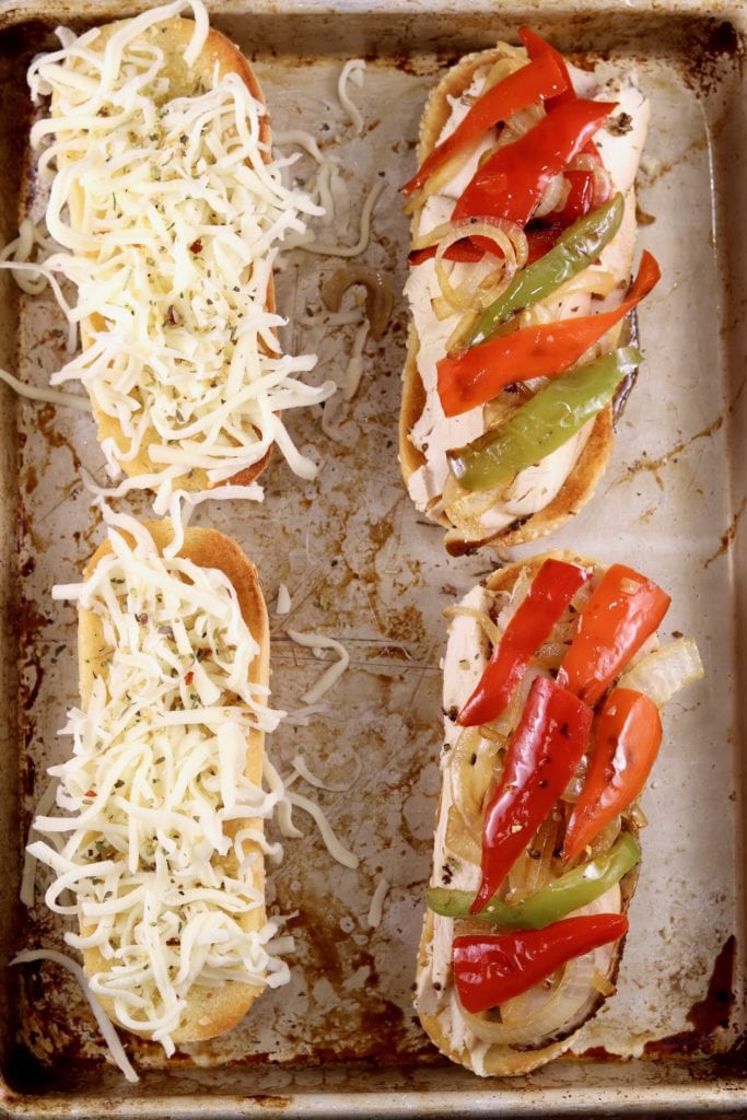 Shredded cheese on a toasted bun, chicken, peppers and onions