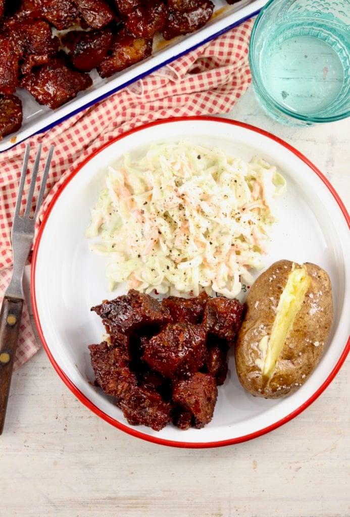 Burnt Ends Barbecue on a plate with baked potato and coleslaw