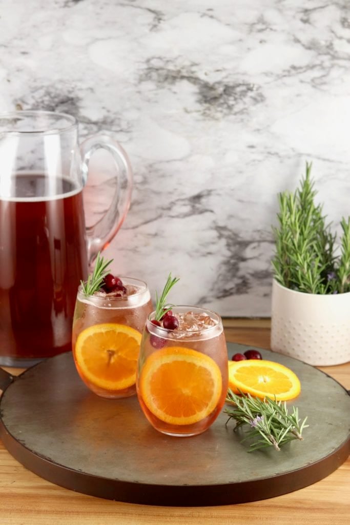 Wine Punch in a pitcher, 2 stemless wine glasses with punch, fresh rosemary garnish