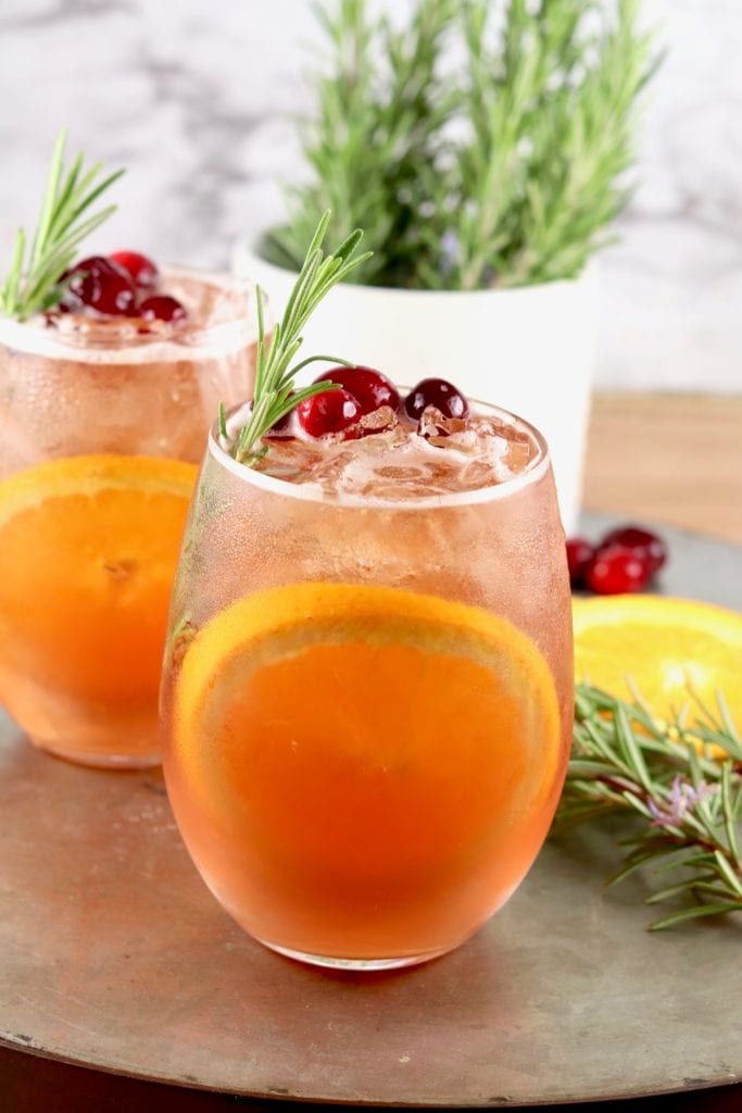 Winter Moscato Cocktail with cranberry and rosemary garnish with an orange slice in the glass