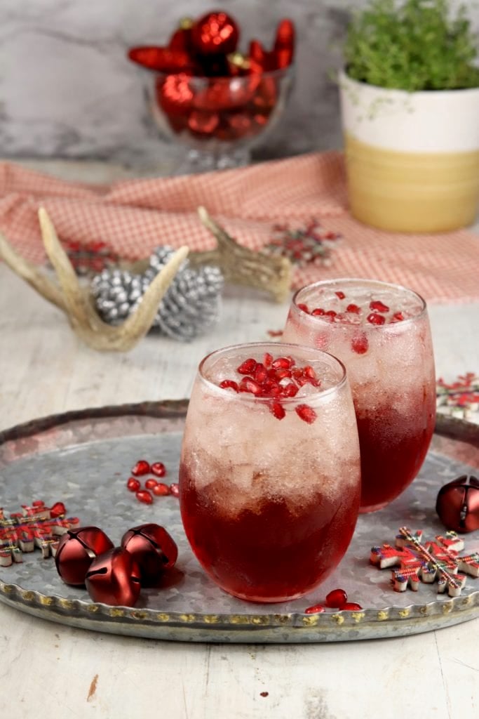 Holiday Pomegranate Mimosas on a platter with Christmas ornaments