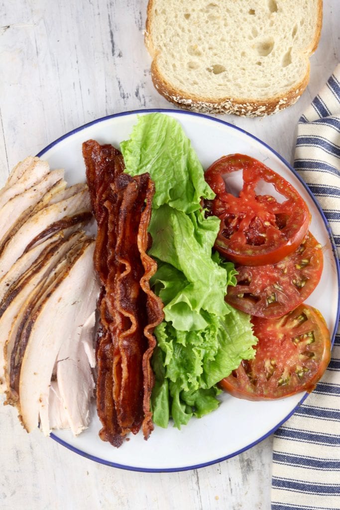 sliced turkey, cooked bacon slices, lettuce and tomato slices
