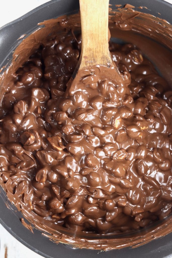 Pan of melted chocolate and peanuts for clusters