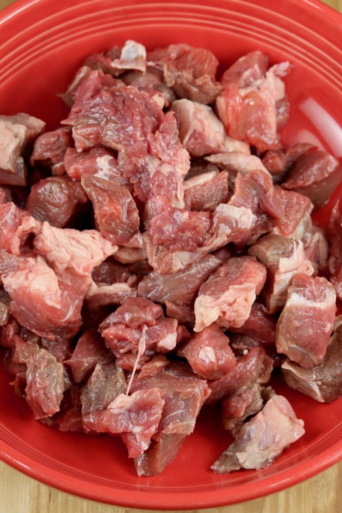 beef stew meat in a red bowl