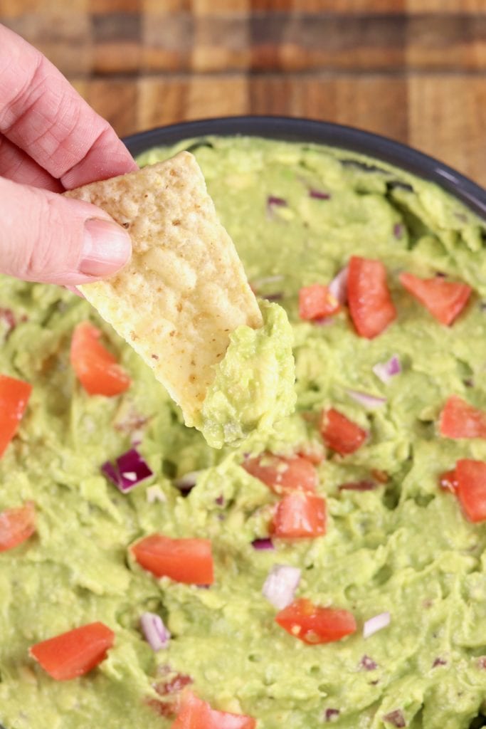 Guacamole dip with tortilla chip dipping