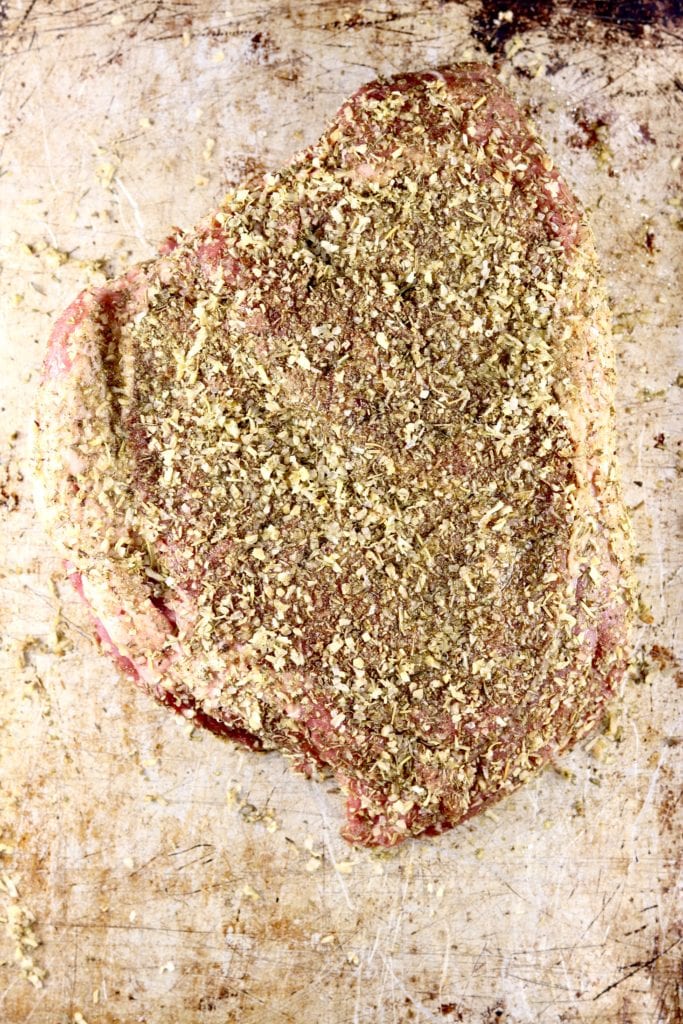 Chuck roast with herb rub on a cookie sheet