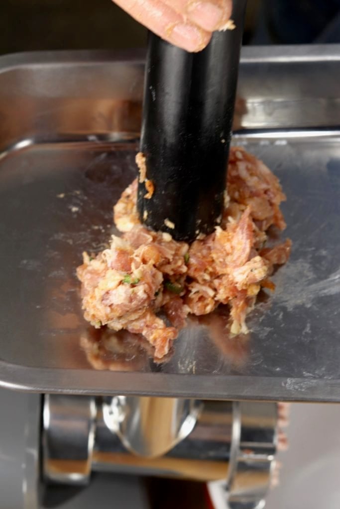 Adding sausage mixture to a meat grinder