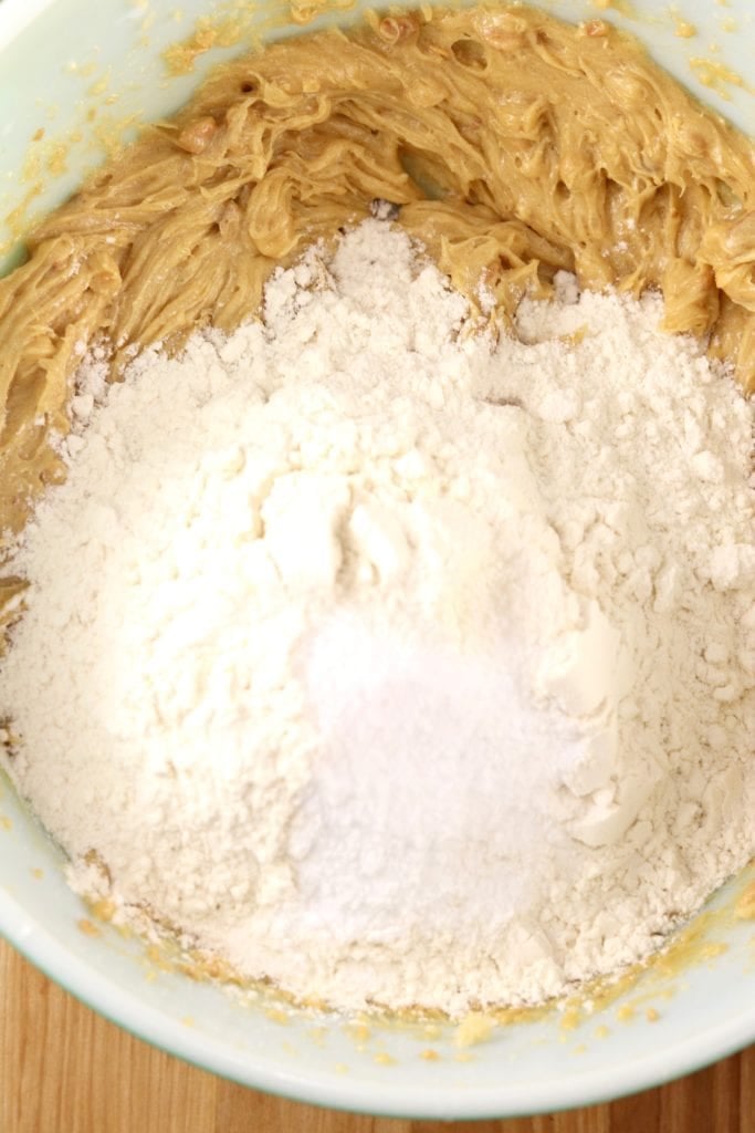 Adding flour to mixing bowl for peanut butter cookie dough