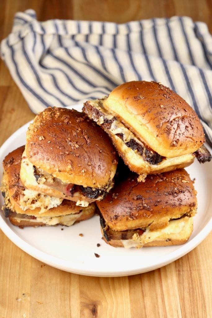 Brisket sliders with melted cheese on a platter