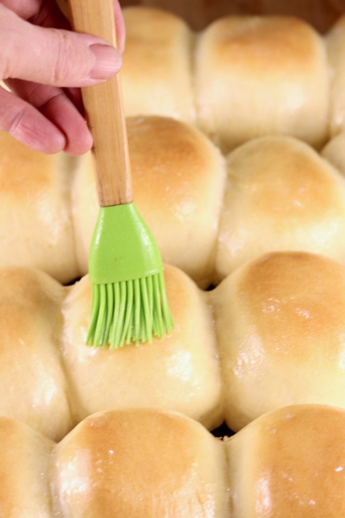brushing dinner rolls with butter