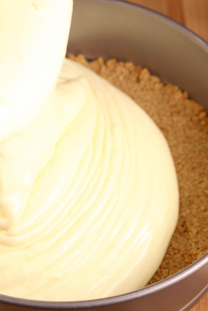 pouring cheesecake into crust for baking