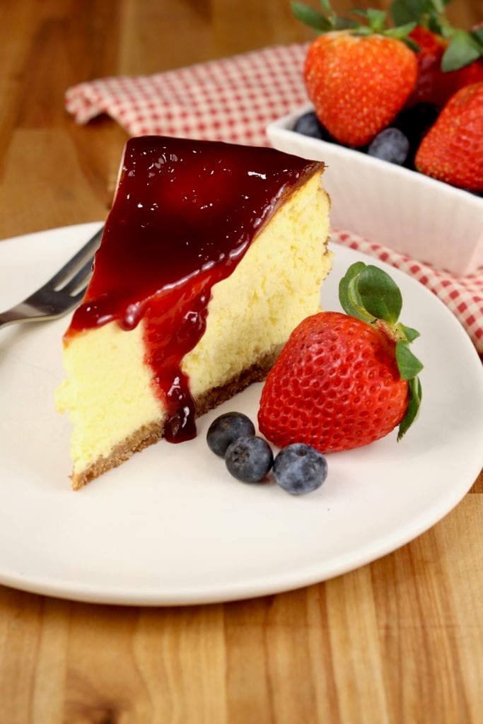 Cheesecake slice with berries and raspberry jam