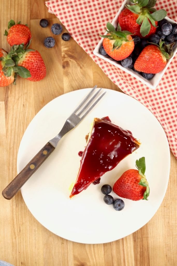 cheesecake slice with raspberry jam and fresh strawberries