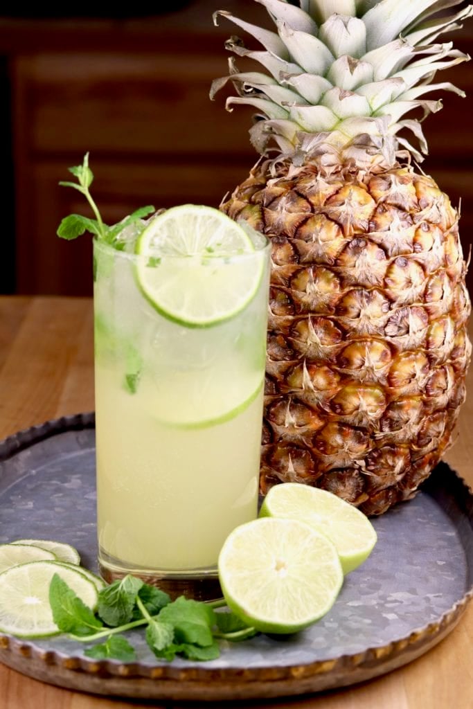 Pineapple Mojito cocktail with a fresh pineapple and lime slices