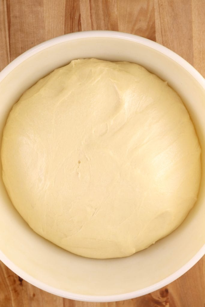Risen milk bread dough in a bowl