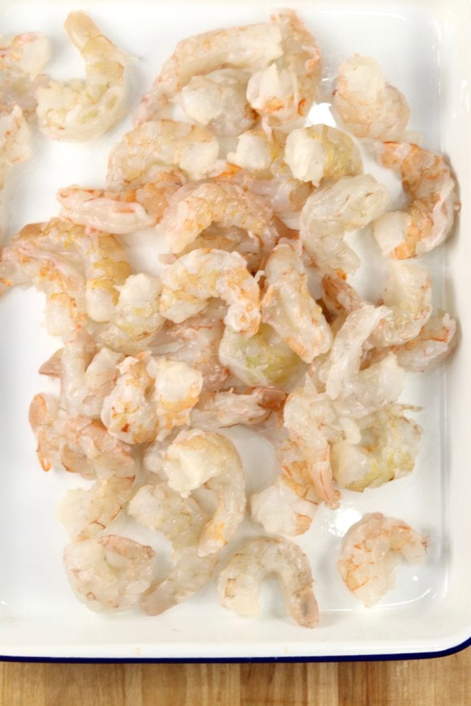 Raw Large shrimp, peeled on a white enameled baking dish