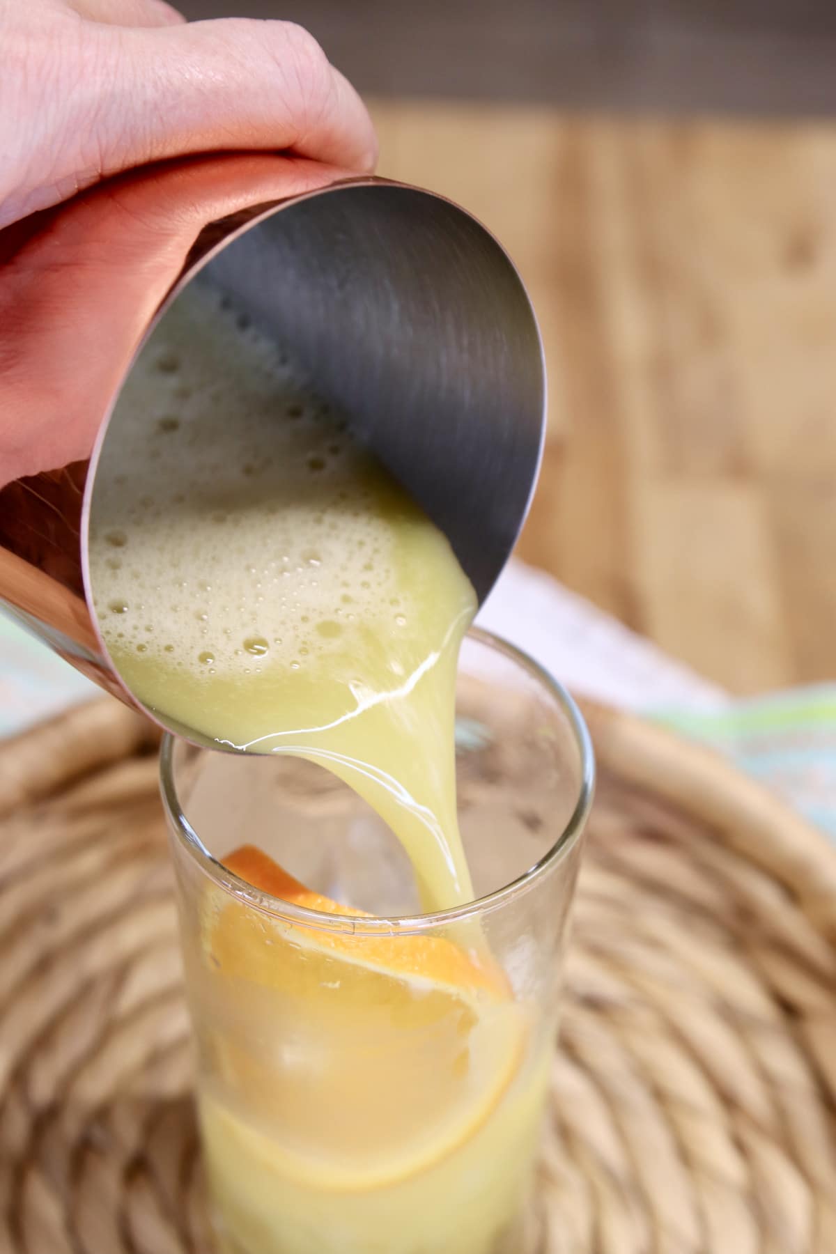 Pouring orange juice cocktail into a glass.