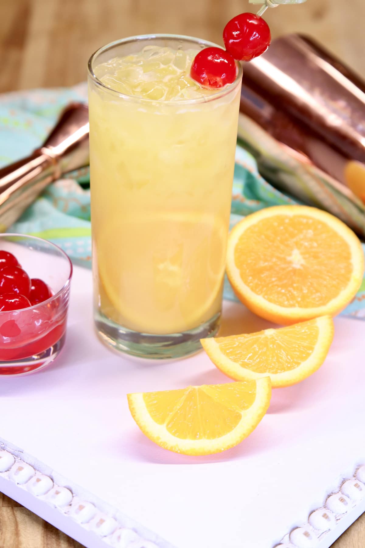 fuzzy screwdriver cocktail with orange slices and cherry garnishes.