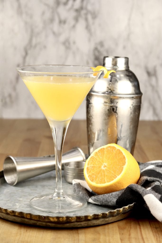 Bees Knees Gin Cocktail with half lemon on a tray + Cocktail shaker
