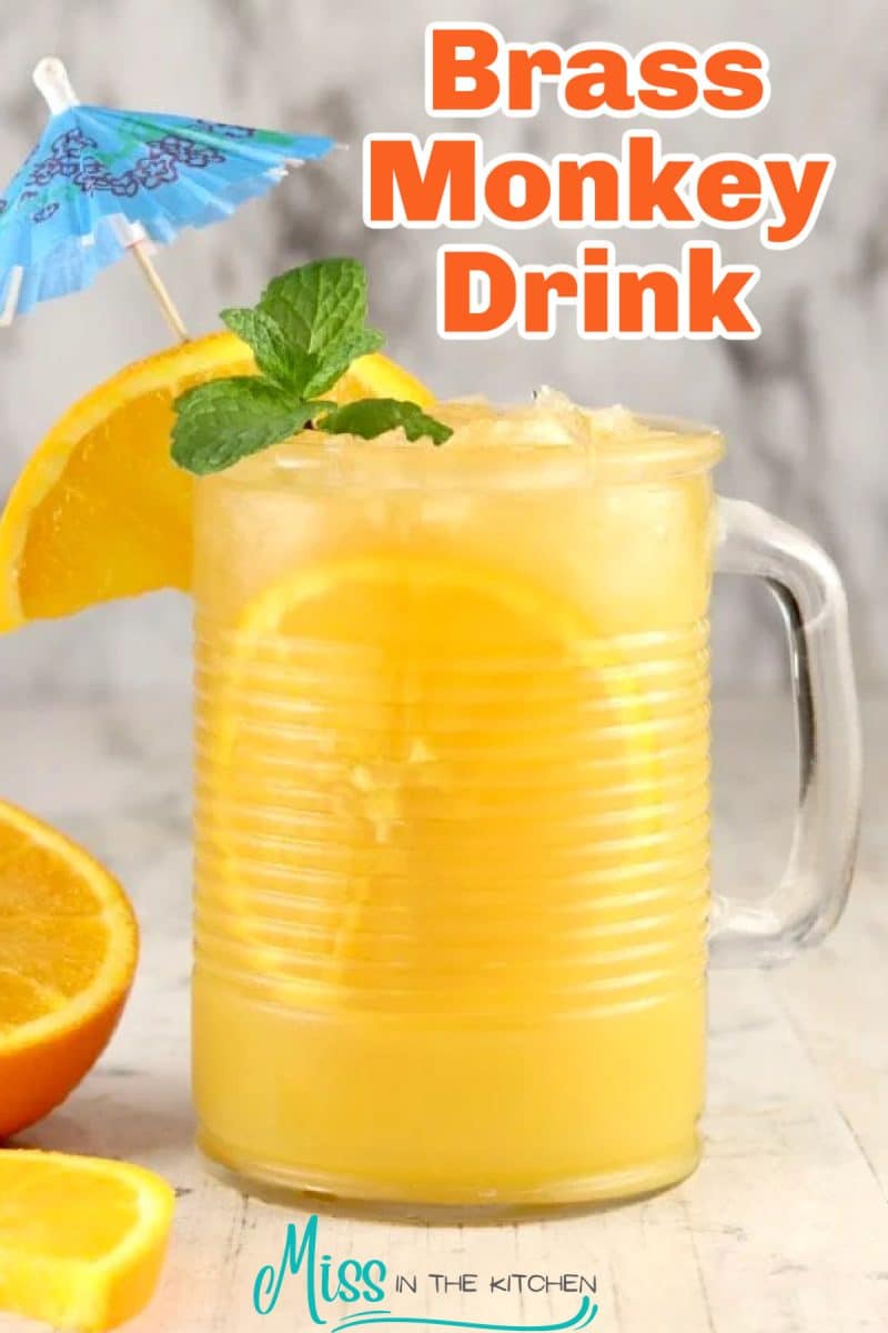 Brass monkey drink in a glass with orange garnish - text overlay.