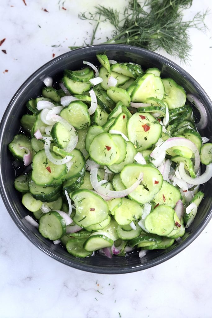 Cucumber Onion Salad with red pepper flakes in a black bowl