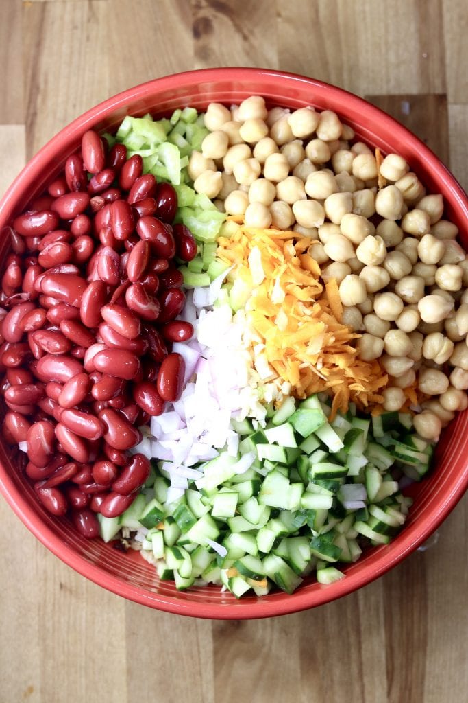 Kidney Beans, chickpeas, cucumbers, carrots, onions and celery in a red bowl 