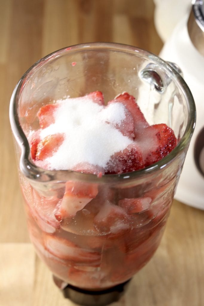 Blender pitcher of strawberries, sugar and lemonade
