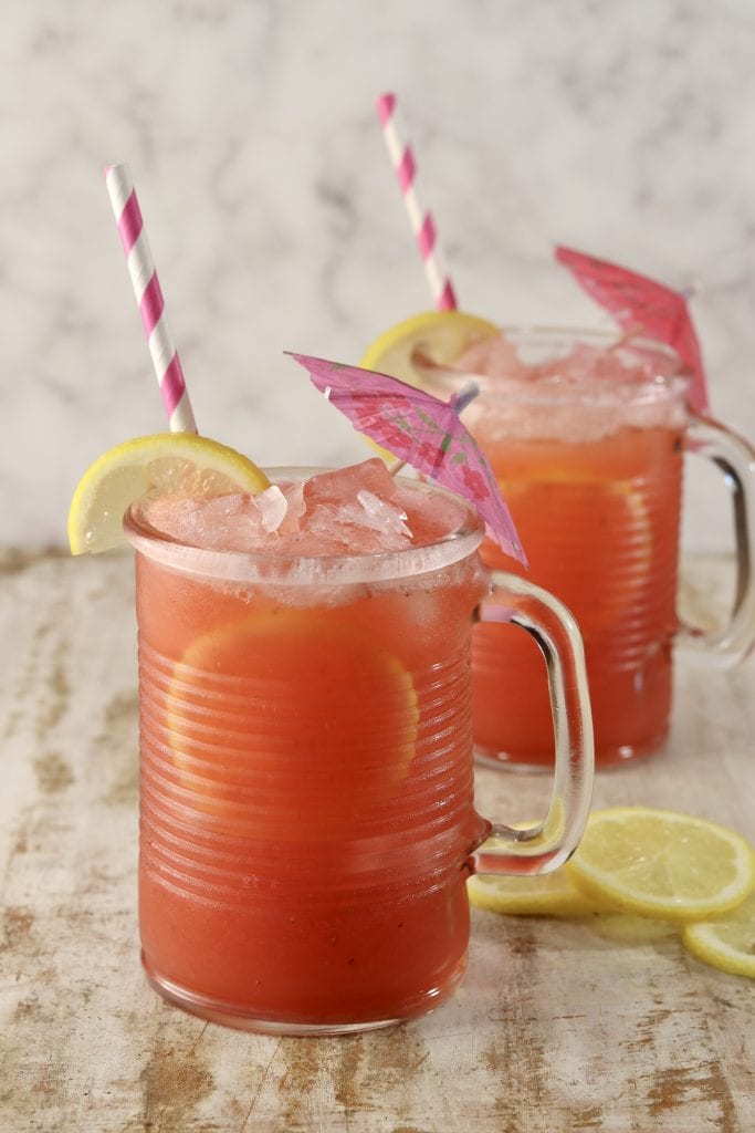 2 mugs of strawberry lemonade, lemon and drink umbrella garnishes
