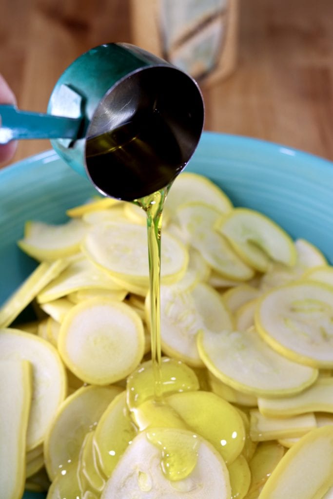 Drizzling sliced squash with olive oil