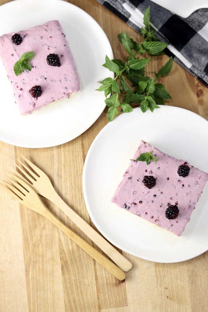 2 plates with a slice of blackberry sheet cake 
