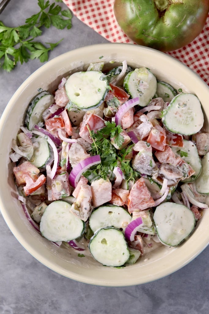 Overhead view of cucumber, tomato, onion salad with creamy dressing
