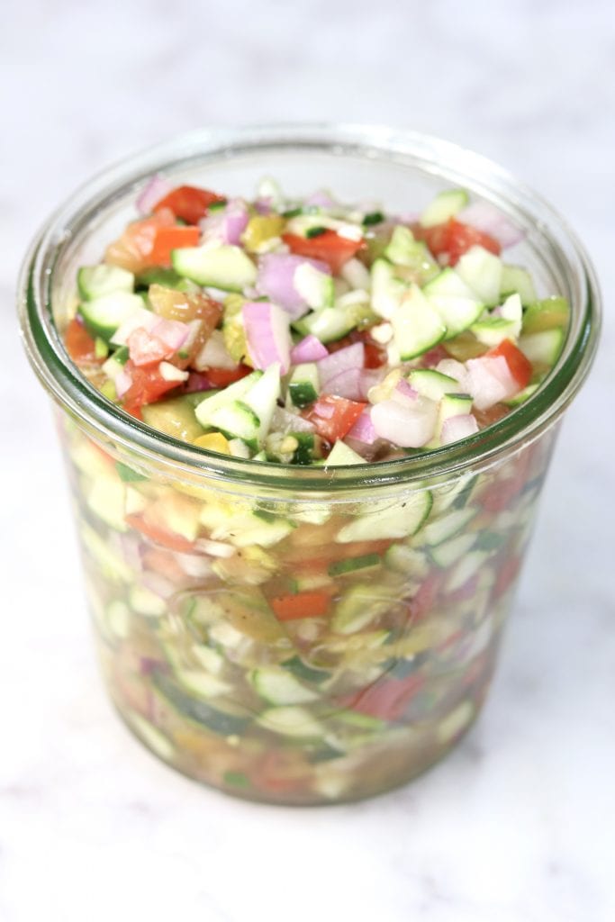 Chopped cucumber tomato and onion salad in a weck jar